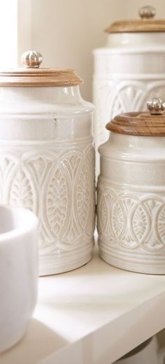 three white canisters sitting on top of a counter