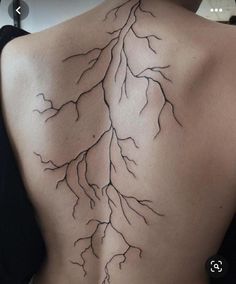 the back of a woman's upper body with branches on her shoulder and lower back