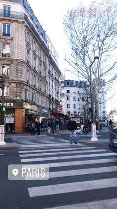 people crossing the street at an intersection in paris