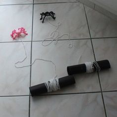 two black and pink objects are on the floor next to each other with string attached