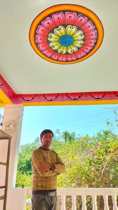 a man standing on a porch with his arms crossed