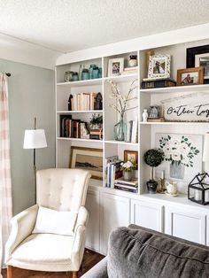 a living room filled with furniture and bookshelves on top of white shelves next to a window