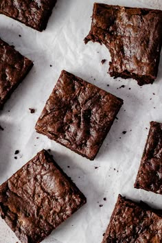 chocolate brownies sitting on top of parchment paper