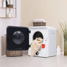 a white microwave oven sitting on top of a counter next to a potted plant