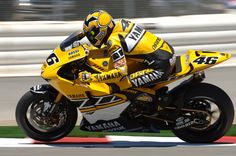 a man riding on the back of a yellow motorcycle