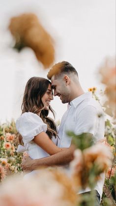 a man and woman standing in a field of flowers