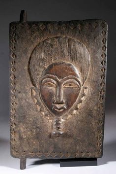 an old metal object with a woman's face on it