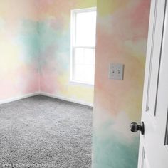 an empty room painted in pastel colors with a light switch on the far wall