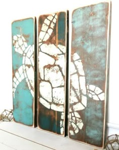 three pieces of wood with sea turtles painted on them