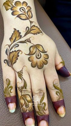 a woman's hand with henna tattoos on it