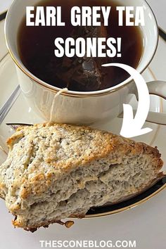 a close up of a cup of tea next to a piece of bread on a plate