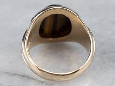 This antique Tiger’s Eye cameo has a silky look, set into a classic rose gold Victorian mounting. The Tiger’s Eye is carved with the image of a Roman man in profile, a classic image for this sort of ring. This is a handsome antique piece, a wonderful addition to one's antique cameo collection! Metal: 14K Antique Rose Gold Gem: Tiger Eye Cameo Gem Measurements: 13.8 x 11.8 mm, Oval Ring Size: 9Marks: “14” Stamped on the inside band Classic Formal Ring With Rotating Bezel, Classic Cameo Rings, Formal Cameo Signet Ring, Roman Man, Gold Tiger Eye, Cameo Ring, Classic Image, Oval Ring, Antique Roses