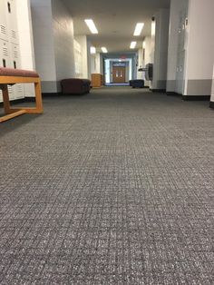 an empty hallway with benches and lockers