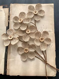 an old book with buttons and flowers on it