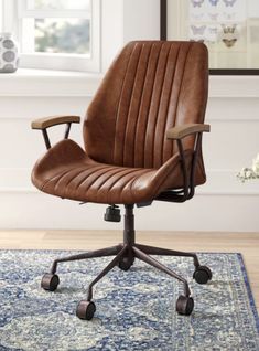 a brown leather office chair sitting on top of a blue rug in front of a window