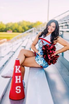 a cheerleader sitting on the bleachers with her pom poms