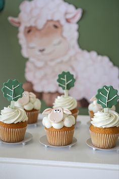 cupcakes with white frosting and green decorations