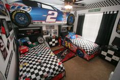 two beds in a room with race cars on the wall and checkered carpeted floor