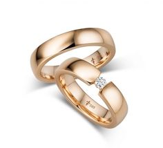 two gold wedding bands with a diamond