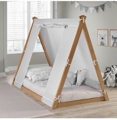 a child's bedroom with a teepee tent bed and stuffed animals on the floor