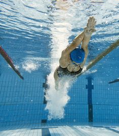 a man swimming underwater in a pool