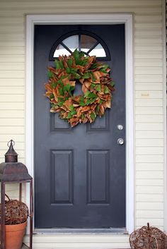 a black front door with a wreath on it