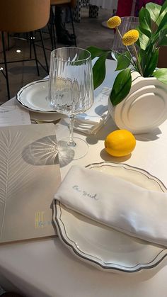 the table is set with plates, napkins, and lemon wedges on it