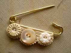 two buttons are attached to a hook on a piece of material that is gold and white