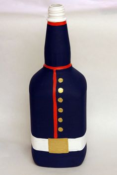 a blue bottle with red, white and gold trimmings on the top is sitting in front of a white background