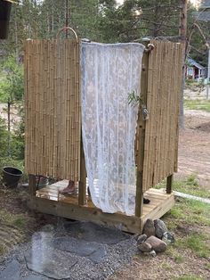 an outhouse made from bamboo with curtains on the outside and in the front yard