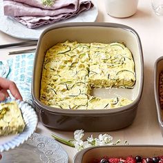 an assortment of desserts are on the table with plates and bowls around them, including cake