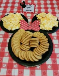 a mickey mouse plate with crackers and cheeses on it at a minnie mouse birthday party