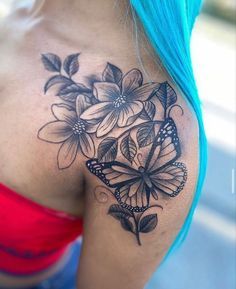 a woman with blue hair has a butterfly and flowers tattoo on her shoulder