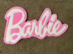 a pink and white towel with the word barbie written in large letters on top of it