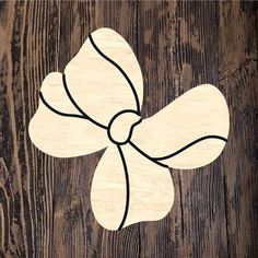 a wooden cutout of a bow on a wood background with black lines in the center