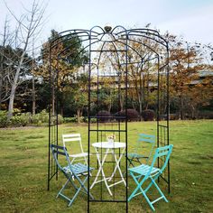 an outdoor table and chairs set up in the grass