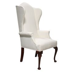 an upholstered white wingback chair with wood trimmings on the legs