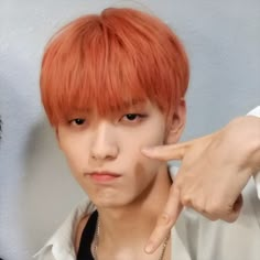 a man with red hair pointing at the camera