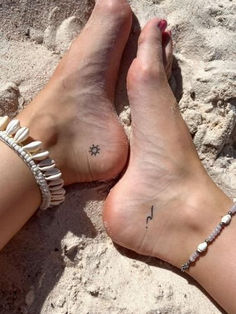 a woman's foot with a star and arrow tattoo on her left ankle in the sand