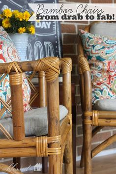 two wicker chairs sitting next to each other in front of a brick wall with colorful pillows