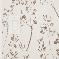 a light switch cover that is decorated with flowers and leaves on a white wallpaper