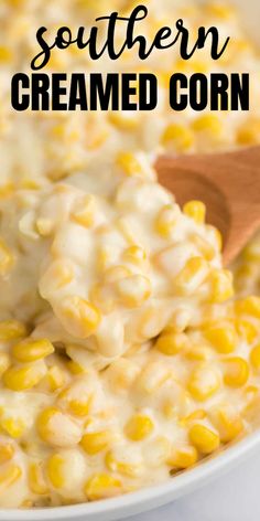 a white bowl filled with creamed corn and topped with a wooden spoon on the side