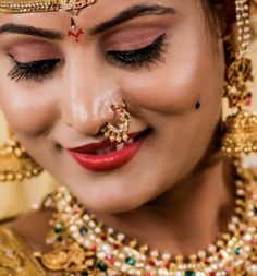 a woman with makeup and jewelry on her face