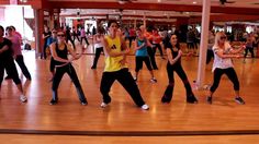 a group of people in a dance class doing various moves with their hands on each other's hips