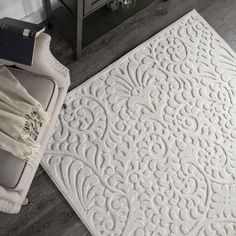 a white rug with an intricate design on the floor