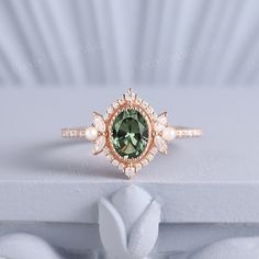 a ring with a green stone surrounded by pearls