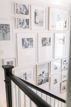 a staircase with many pictures on the wall and some black and white photos above it