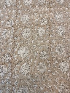 an embroidered fabric with white flowers and leaves on the side, as well as a pattern