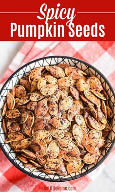 a bowl filled with pumpkin seeds on top of a red and white checkered table cloth