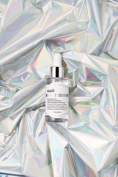 a bottle of klair's whitening solution sitting on top of silver foil